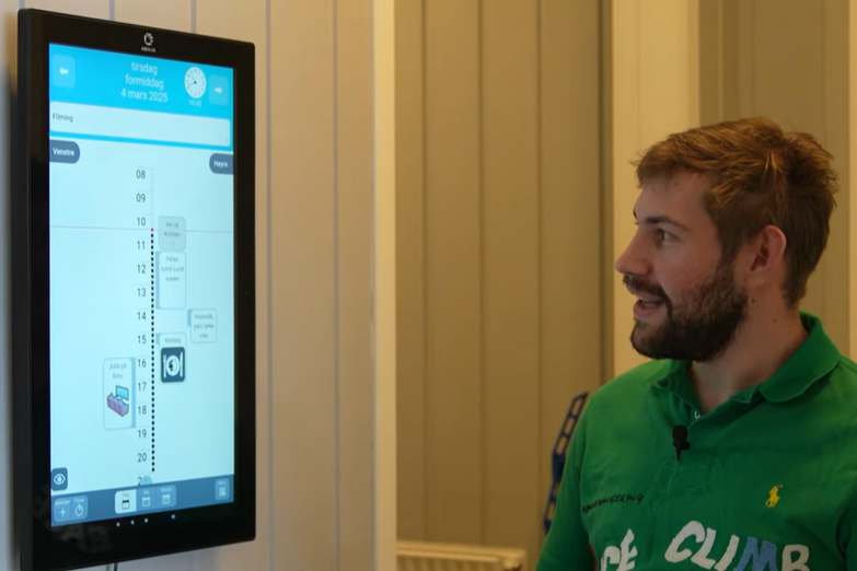 Man smiling looking at digital device mounted on wall